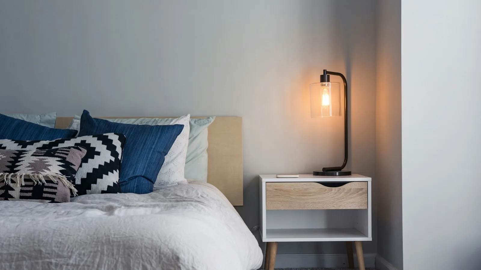 Opgemaakt bed in een rustige, donkere slaapkamer
